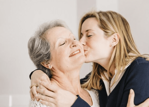 A Daughter is Giving Her Mom A Big Kiss